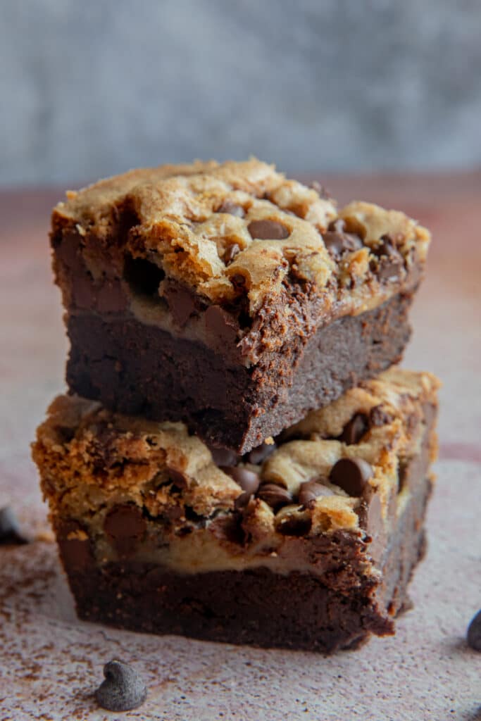 Two Brookie squares on top of each other with chocolate chips scattered around them.