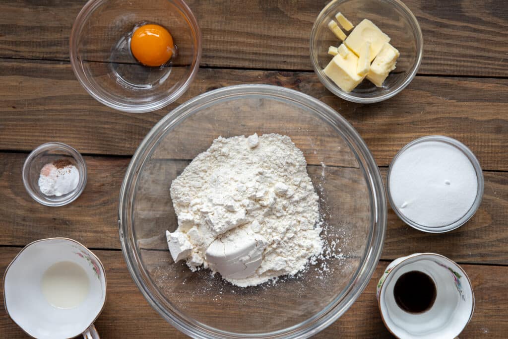 Ingredients to make vanilla sugar cookies in separate bowls.