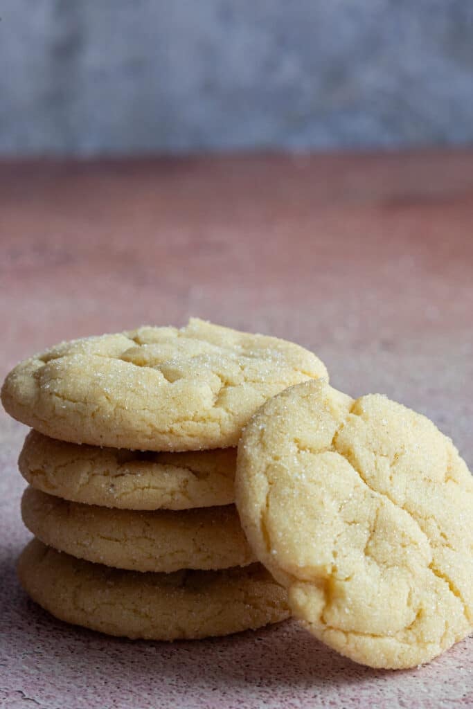 Four sugar cookies stacked with one leaning on the side.