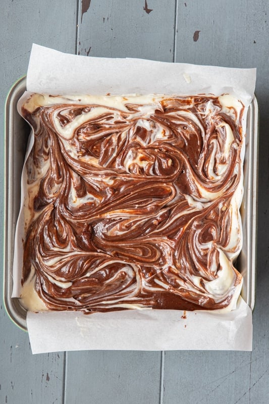 Marbled cream cheese brownie mix in a baking pan.