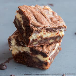 Two cheesecake brownie bard stacked.