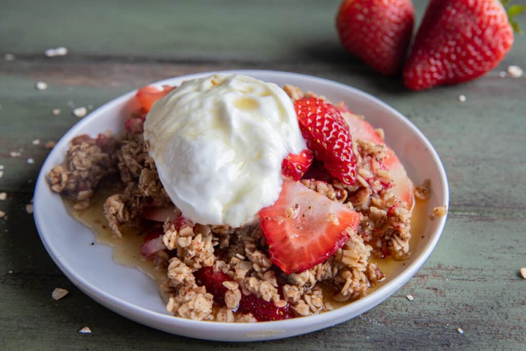 Crumble on a white plate with a dollop of greek yogurt.