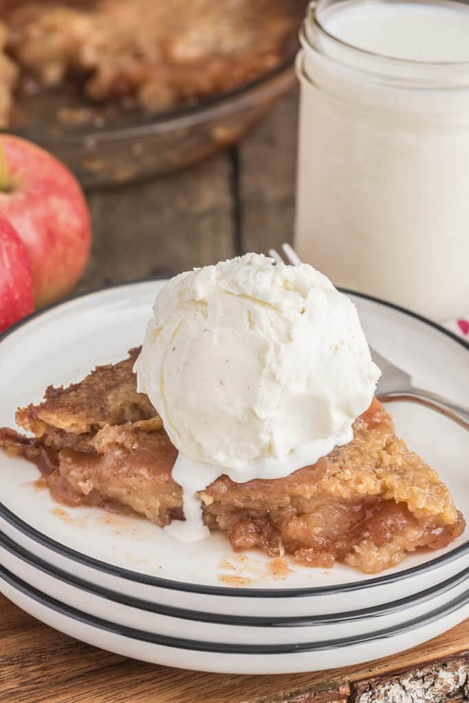 A slice of bottomless apple pie with a scoop of vanilla ice cream on top.