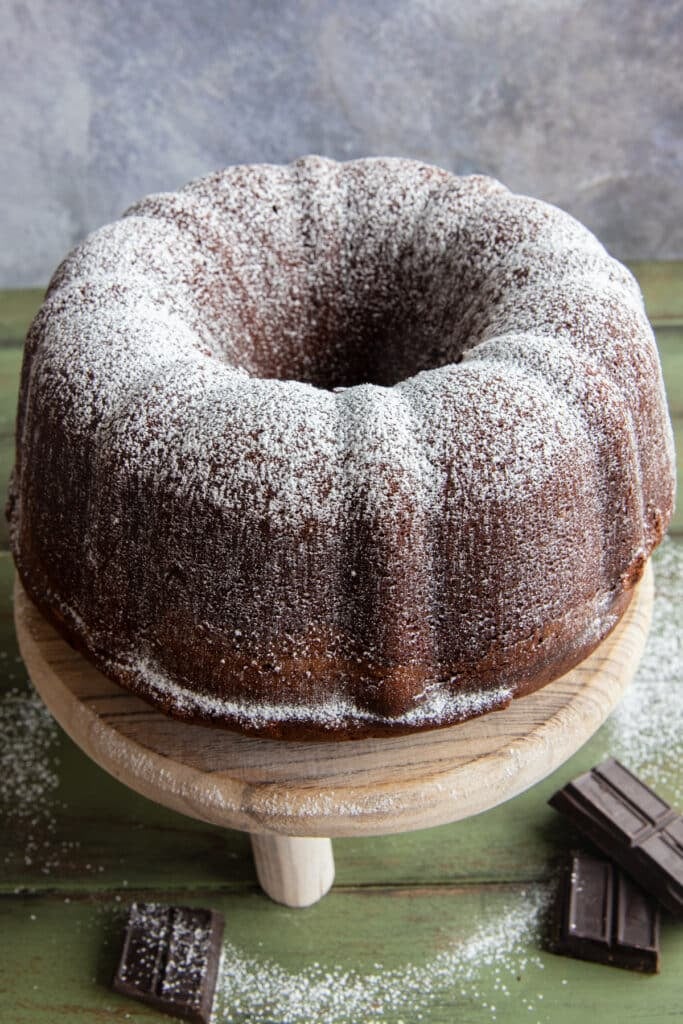 Chocolate pound cake on a wooden cake stand.