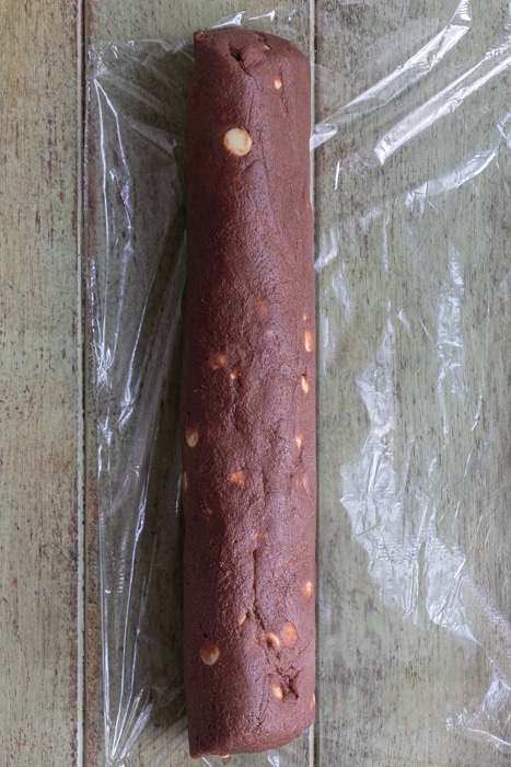 Cookie dough shaped into a log on top of plastic wrap.
