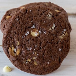 White chocolate chip cookies stacked with one leaning in front of them.