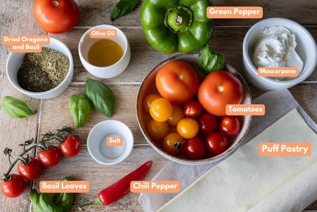 Tomato and mascarpone ingredients in separate bowls and sat on a wooden counter.
