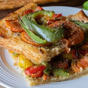 Two slices of tomato and mascarpone tart on a white plate.