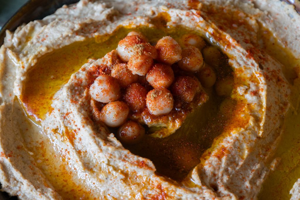 Homemade hummus topped with whole chickpeas and olive oil.
